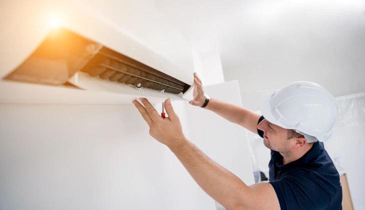 le technicien nettoie le système de climatisation dans un appartement moderne