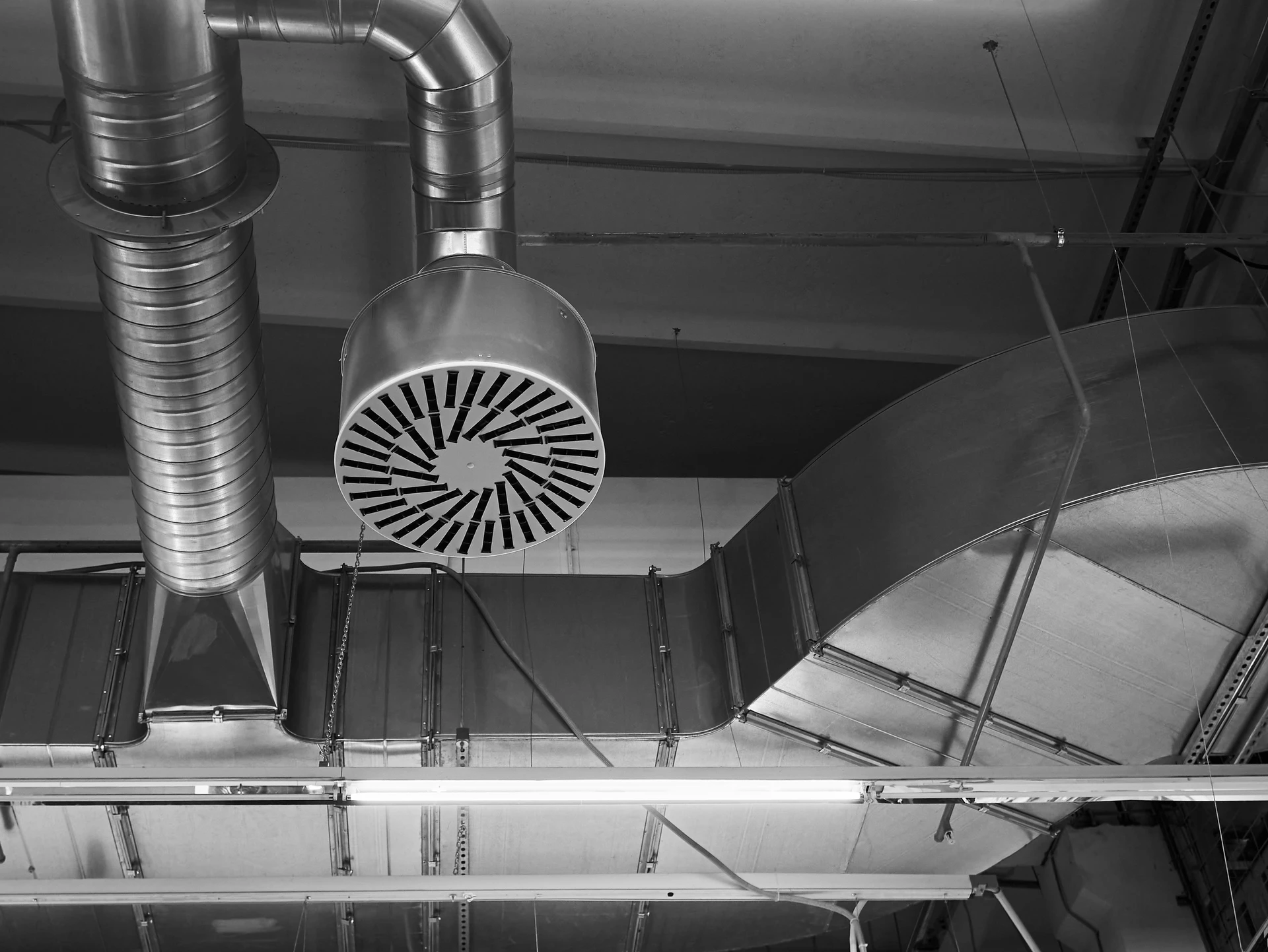 Système de ventilation et de climatisation dans des locaux industriels ou commerciaux avec éclairage, sous le plafond