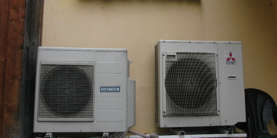 Mécanicien automobile tenant un manomètre de climatisation dans un garage