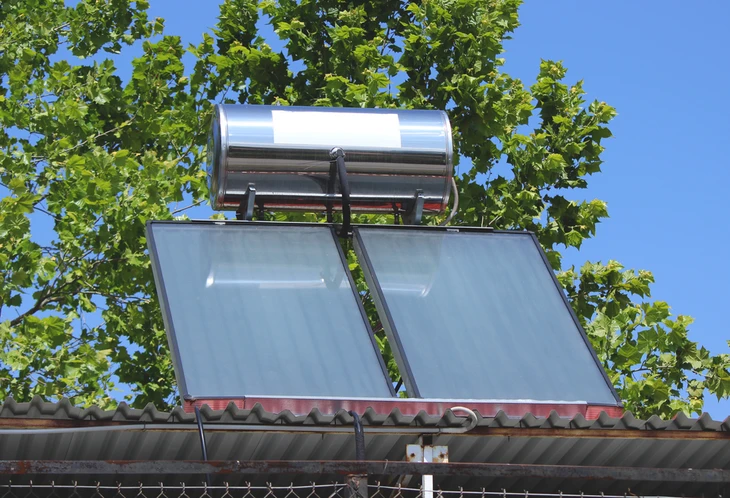 Extérieur ensoleillé avec chauffe-eau solaire installé sur toiture de maison résidentielle