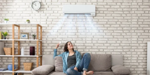 Intérieur résidentiel avec climatiseur mural blanc installé en hauteur sur mur beige