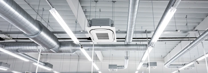 Intérieur d'un bâtiment commercial ou industriel avec plafond suspendu exposant l'infrastructure technique
