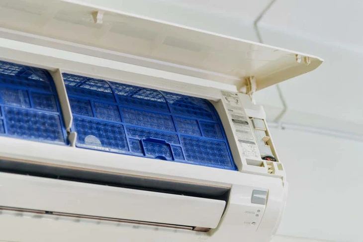 Intérieur climatisé avec unité murale ouverte révélant le système de filtration et les composants internes