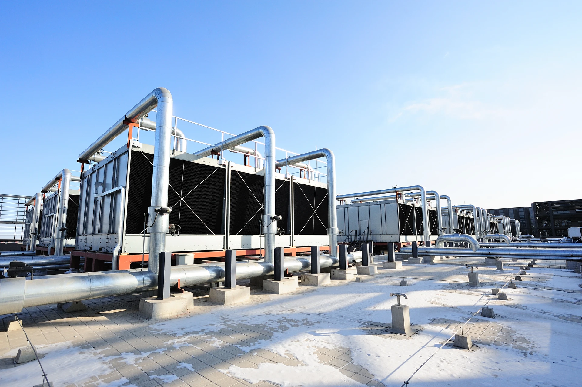 Installations industrielles de refroidissement sur toiture d'immeuble sous ciel bleu