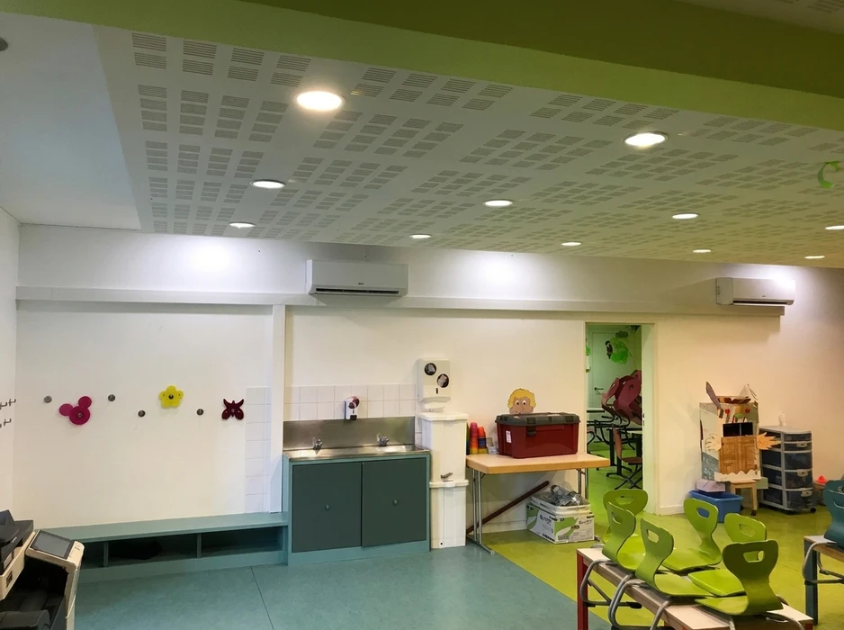 Salle de classe maternelle équipée de deux climatiseurs split-system muraux, plafond acoustique perforé avec spots LED encastrés
