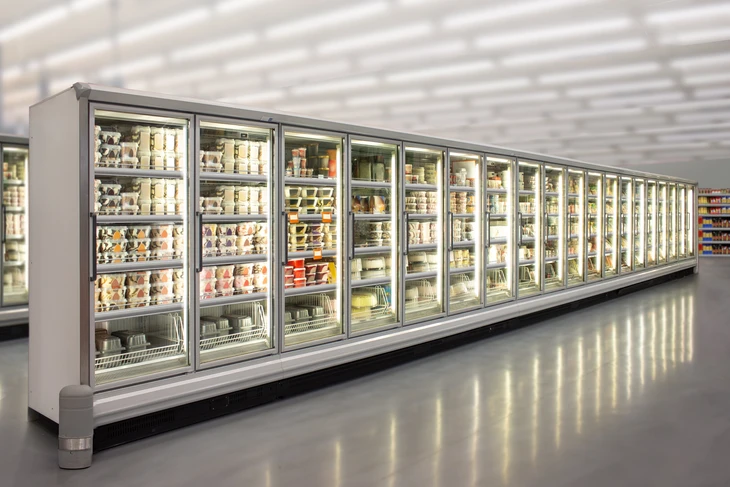 Intérieur de supermarché avec allée de réfrigérateurs commerciaux vitrés alignés