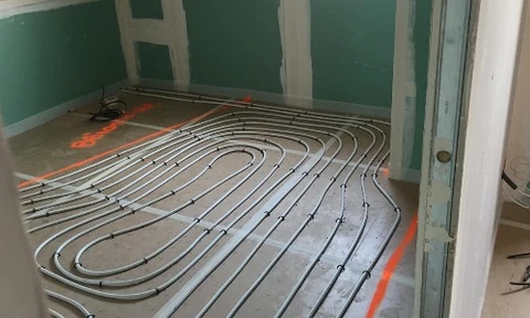 Extérieur résidentiel avec unité de climatisation installée sur dalle béton devant maison bleue