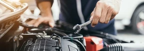 Mécanicien automobile travaillant sur moteur de véhicule dans garage professionnel