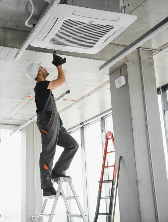 Extérieur résidentiel avec unité de climatisation centrale installée sur pelouse verte près d'un mur de briques rouges